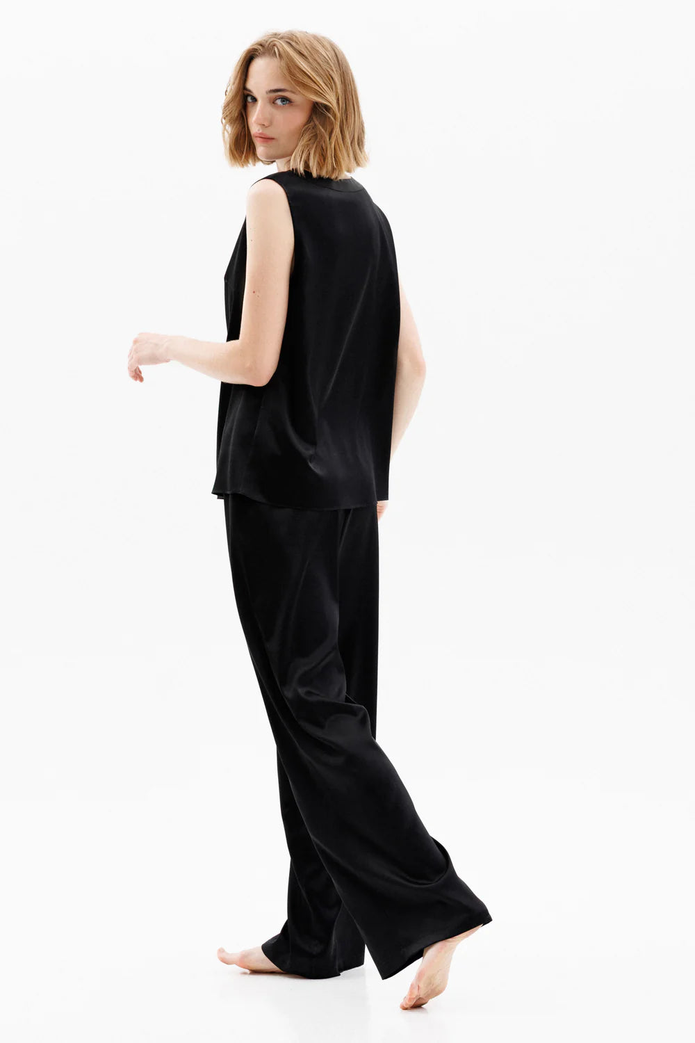 Woman wearing a black silk sleeveless top (sold separately) and black silk pants showing the back