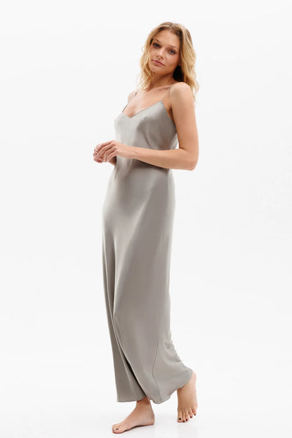 Woman wearing a long silk gray slip dress on a spaghetti straps