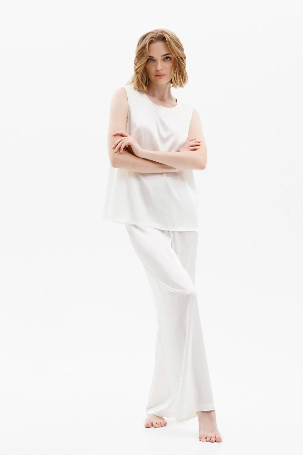 Woman wearing a white silk sleeveless top and pants (sold separately) showing the front full look