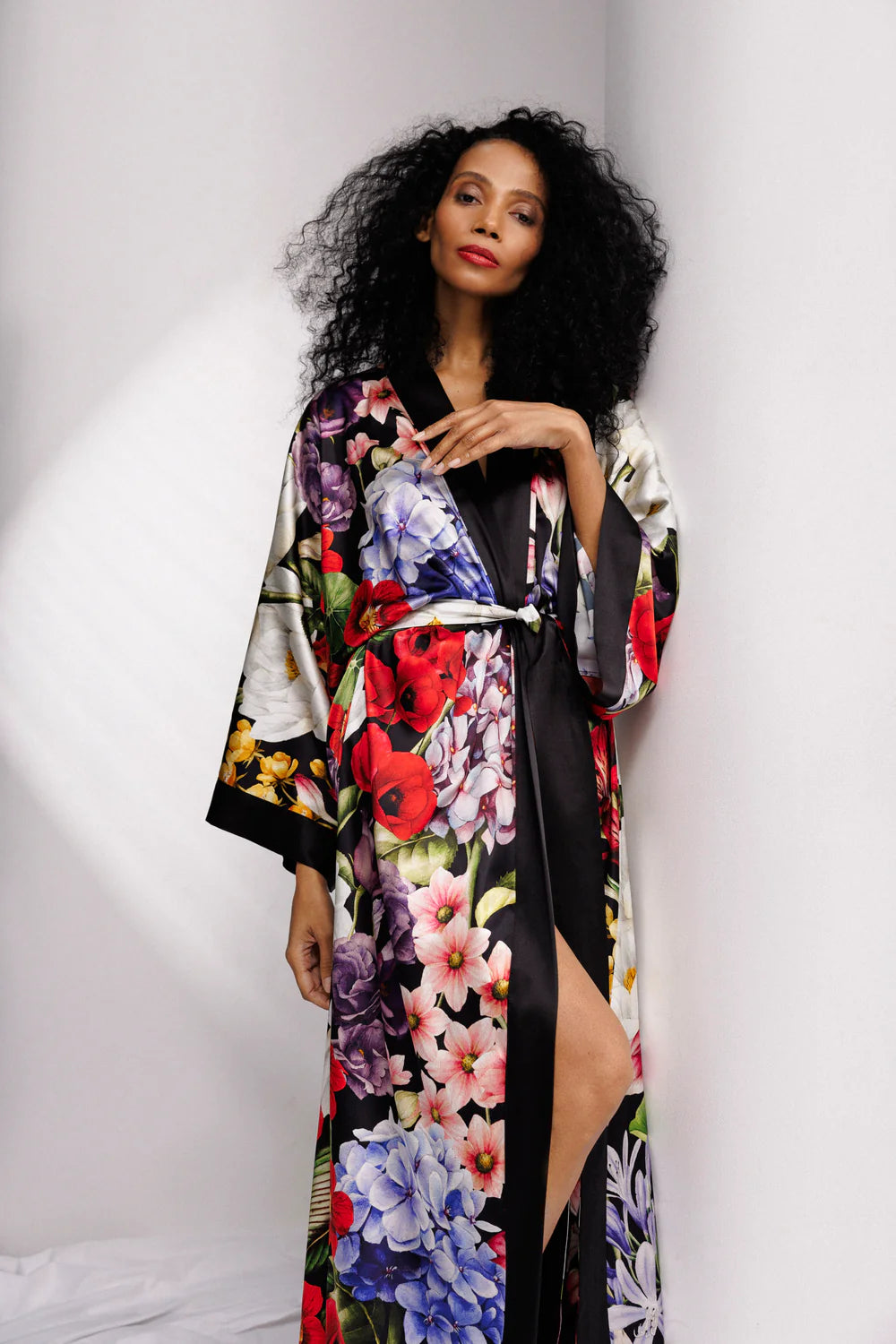 Woman wearing a colorful floral silk kimono over full length nightgown, sold separately. full front picture