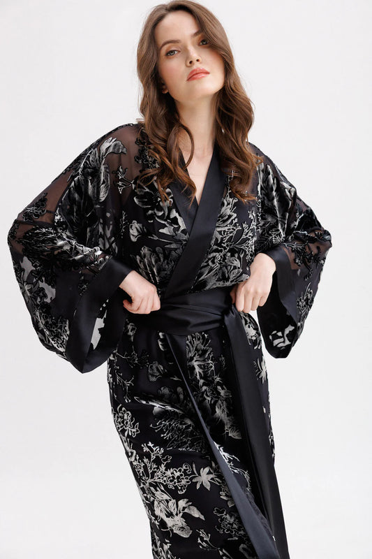 Woman wearing a black floral silk velvet kimono with wide belt. Front picture