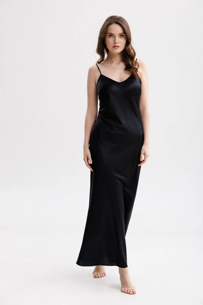 Woman wearing a long silk black slip dress on a spaghetti straps