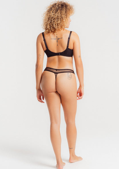 The Chantilly line by Louisa Bracq thong features a geometric border-line complemented by shimmering iridescent medallions, providing a sophisticated and refined air. 